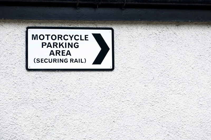 An image of a black and white Motorcycle Parking Area exterior wayfinding sign.